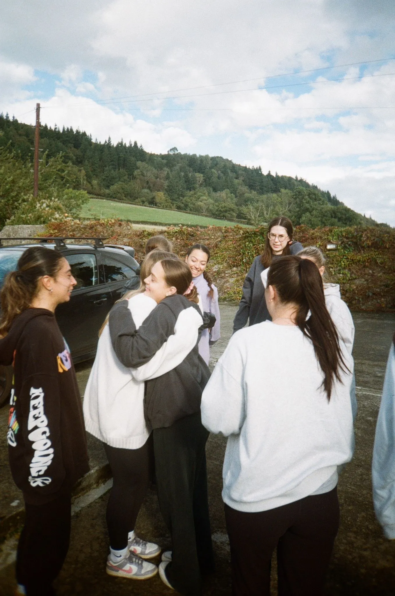 Women hugging each other outside in the hills, shot on film