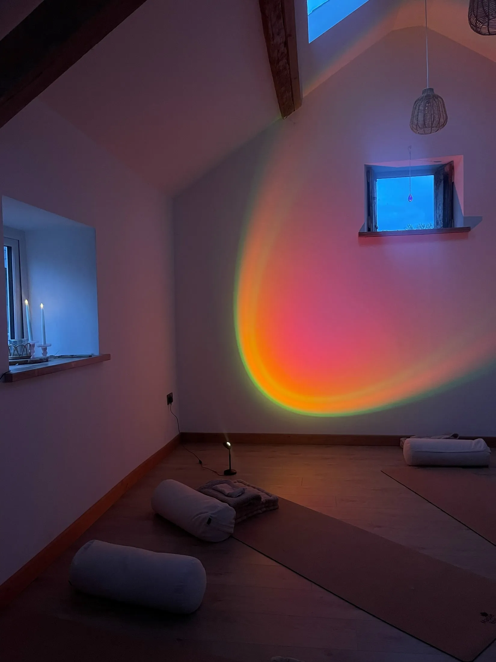 An empty studio with cushions, glowing pink and orange